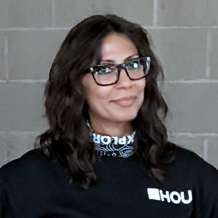 Sara Iqbal, Design Advocacy Director for AIGA Houston wearing black sweater and printed black scarf with AIGA Houston logo and typography.